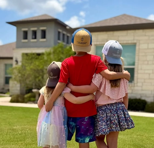 Children standing together outside a Texas home